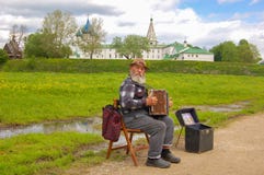 Ρωσία suzdal 28 Μαΐου 2017 Μουσικός οδών, παλαιός παππούς με το ακκορντέον του στο υπόβαθρο του Κρεμλίνου του Σούζνταλ στοκ φωτογραφία με δικαίωμα ελεύθερης χρήσης Ρωσία suzdal 28 Μαΐου 2017 Μουσικός οδών, παλαιός παππούς με το ακκορντέον του στο υπόβαθρο του Κρεμλίνου του Σούζνταλ στοκ φωτογραφία με δικαίωμα ελεύθερης χρήσης