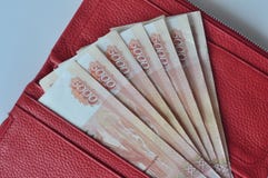 Ρωσικά τραπεζογραμμάτια 5000 ρούβλια στο κόκκινο πορτοφόλι γυναικών στοκ εικόνες Ρωσικά τραπεζογραμμάτια 5000 ρούβλια στο κόκκινο πορτοφόλι γυναικών στοκ εικόνες