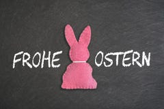 Ρόδινο λαγουδάκι Πάσχας με το κείμενο “Frohe Ostern “σε ένα υπόβαθρο πινάκων κιμωλίας Μετάφραση: “Ευτυχές Πάσχα “ στοκ εικόνες Ρόδινο λαγουδάκι Πάσχας με το κείμενο “Frohe Ostern “σε ένα υπόβαθρο πινάκων κιμωλίας Μετάφραση: “Ευτυχές Πάσχα “ στοκ εικόνες