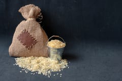 Ρύζι στο σάκο κάδων και burlap στο σκοτεινό υπόβαθρο στοκ εικόνες με δικαίωμα ελεύθερης χρήσης Ρύζι στο σάκο κάδων και burlap στο σκοτεινό υπόβαθρο στοκ εικόνες με δικαίωμα ελεύθερης χρήσης