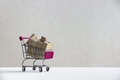 Σε ένα άσπρο πάτωμα σε ένα άσπρο υπόβαθρο υπάρχει ένα καροτσάκι αγορών με τους ξύλινους φραγμούς των πινάκων στοκ φωτογραφία με δικαίωμα ελεύθερης χρήσης Σε ένα άσπρο πάτωμα σε ένα άσπρο υπόβαθρο υπάρχει ένα καροτσάκι αγορών με τους ξύλινους φραγμούς των πινάκων στοκ φωτογραφία με δικαίωμα ελεύθερης χρήσης