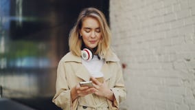 Σε αργή κίνηση του αρκετά νέου smartphone γυναικείας εκμετάλλευσης σχετικά με την οθόνη και τον καφέ κατανάλωσης Τόγκο υπαίθρια l απόθεμα βίντεο Σε αργή κίνηση του αρκετά νέου smartphone γυναικείας εκμετάλλευσης σχετικά με την οθόνη και τον καφέ κατανάλωσης Τόγκο υπαίθρια l απόθεμα βίντεο