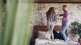 Σε αργή κίνηση των ευτυχών νέων εραστών που χορεύουν στο διπλό κρεβάτι που έχει τη διασκέδαση στην κρεβατοκάμαρα και που γελά απρ απόθεμα βίντεο Σε αργή κίνηση των ευτυχών νέων εραστών που χορεύουν στο διπλό κρεβάτι που έχει τη διασκέδαση στην κρεβατοκάμαρα και που γελά απρ απόθεμα βίντεο