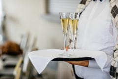 Σερβιτόρα που κρατά ένα πιάτο των γυαλιών σαμπάνιας και κρασιού σε κάποιο Φε στοκ φωτογραφίες Σερβιτόρα που κρατά ένα πιάτο των γυαλιών σαμπάνιας και κρασιού σε κάποιο Φε στοκ φωτογραφίες