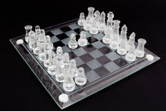 Σκάκι γυαλιού σε ένα μαύρο υπόβαθρο Η αρχή του κόμματος στοκ εικόνες Σκάκι γυαλιού σε ένα μαύρο υπόβαθρο Η αρχή του κόμματος στοκ εικόνες