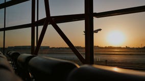 Σκιαγραφία ενός αεροπλάνου που απογειώνεται στο ηλιοβασίλεμα στον αερολιμένα του Πεκίνου στο υπόβαθρο ενός παραθύρου Σκιαγραφία ενός αεροπλάνου που απογειώνεται στο ηλιοβασίλεμα στον αερολιμένα του Πεκίνου στο υπόβαθρο ενός παραθύρου