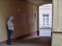 Σκιαγραφία ενός ατόμου σε μια κουκούλα στην παλαιά αψίδα προαυλίων στοκ εικόνες με δικαίωμα ελεύθερης χρήσης Σκιαγραφία ενός ατόμου σε μια κουκούλα στην παλαιά αψίδα προαυλίων στοκ εικόνες με δικαίωμα ελεύθερης χρήσης