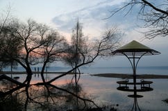 Σκιαγραφίες του άνδρα και της γυναίκας στην παραλία στα πλαίσια μιας πτώσης πέρα από τη λίμνη στοκ εικόνες με δικαίωμα ελεύθερης χρήσης Σκιαγραφίες του άνδρα και της γυναίκας στην παραλία στα πλαίσια μιας πτώσης πέρα από τη λίμνη στοκ εικόνες με δικαίωμα ελεύθερης χρήσης