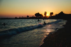 Σκιαγραφίες των ευτυχών ανθρώπων που κολυμπούν και που παίζουν στη θάλασσα στο ηλιοβασίλεμα, έννοια για την κατοχή της διασκέδαση στοκ εικόνες Σκιαγραφίες των ευτυχών ανθρώπων που κολυμπούν και που παίζουν στη θάλασσα στο ηλιοβασίλεμα, έννοια για την κατοχή της διασκέδαση στοκ εικόνες