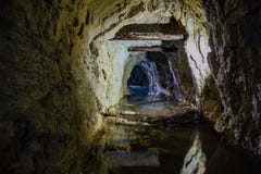 Σκοτεινή ανατριχιαστική βρώμικη πλημμυρισμένη εγκαταλειμμένη σήραγγα ορυχείων στοκ εικόνες Σκοτεινή ανατριχιαστική βρώμικη πλημμυρισμένη εγκαταλειμμένη σήραγγα ορυχείων στοκ εικόνες