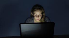Σοβαρή νέα γυναίκα που εργάζεται στο lap-top στο σκοτεινό δωμάτιο απόθεμα βίντεο Σοβαρή νέα γυναίκα που εργάζεται στο lap-top στο σκοτεινό δωμάτιο απόθεμα βίντεο