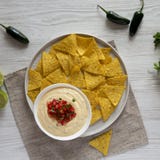 Σπιτική τυροειδής εμβύθιση με τα nachos πέρα από την άσπρη ξύλινη επιφάνεια, τοπ άποψη r στοκ φωτογραφία με δικαίωμα ελεύθερης χρήσης Σπιτική τυροειδής εμβύθιση με τα nachos πέρα από την άσπρη ξύλινη επιφάνεια, τοπ άποψη r στοκ φωτογραφία με δικαίωμα ελεύθερης χρήσης