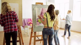 Σπουδαστές με easels που χρωματίζουν στο σχολείο τέχνης Σπουδαστές με easels που χρωματίζουν στο σχολείο τέχνης