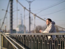 Στάσεις νεαρών άνδρων μόνο σε μια γέφυρα μια ηλιόλουστη ημέρα, οπισθοσκόπο, copyspace στοκ εικόνες Στάσεις νεαρών άνδρων μόνο σε μια γέφυρα μια ηλιόλουστη ημέρα, οπισθοσκόπο, copyspace στοκ εικόνες