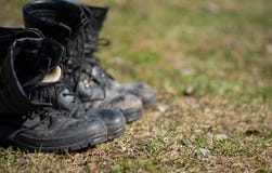 Στάση μποτών στρατού σε μια σειρά στη χλόη στοκ φωτογραφίες Στάση μποτών στρατού σε μια σειρά στη χλόη στοκ φωτογραφίες
