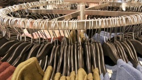 Στη μεγάλη στρογγυλή κρεμάστρα υπάρχουν διάφορα μοντέρνα πλεκτά πολύχρωμα πουλόβερ που κρεμούν στις μαύρες κρεμάστρες μόδας στο α απόθεμα βίντεο Στη μεγάλη στρογγυλή κρεμάστρα υπάρχουν διάφορα μοντέρνα πλεκτά πολύχρωμα πουλόβερ που κρεμούν στις μαύρες κρεμάστρες μόδας στο α απόθεμα βίντεο