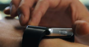 Στην αρχή ένα άτομο που χρησιμοποιεί το smartwatch του Η ακραία κινηματογράφηση σε πρώτο πλάνο δίνει την ψηφιακή τεχνολογία συσκε φιλμ μικρού μήκους Στην αρχή ένα άτομο που χρησιμοποιεί το smartwatch του Η ακραία κινηματογράφηση σε πρώτο πλάνο δίνει την ψηφιακή τεχνολογία συσκε φιλμ μικρού μήκους