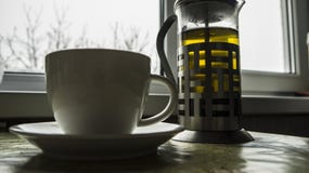Στην κουζίνα στον πίνακα είναι teapot με το τσάι στο κοντινό αεροπλάνο είναι ένα φλυτζάνι στοκ φωτογραφία με δικαίωμα ελεύθερης χρήσης Στην κουζίνα στον πίνακα είναι teapot με το τσάι στο κοντινό αεροπλάνο είναι ένα φλυτζάνι στοκ φωτογραφία με δικαίωμα ελεύθερης χρήσης