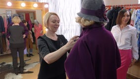 Στιλίστας μόδας που βοηθά να επιλέξει το νέο παλτό για την ώριμη γυναίκα στη μπουτίκ ενδυμάτων Ανώτερη γυναίκα που δοκιμάζει το π απόθεμα βίντεο Στιλίστας μόδας που βοηθά να επιλέξει το νέο παλτό για την ώριμη γυναίκα στη μπουτίκ ενδυμάτων Ανώτερη γυναίκα που δοκιμάζει το π απόθεμα βίντεο