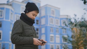 Στις στάσεις προαυλίων ένα αγόρι στο μονοπάτι Φόρεσε ένα σακάκι, ένα μαύρο καπέλο και ένα μαντίλι γύρω από το λαιμό του Έπαιξε στ απόθεμα βίντεο Στις στάσεις προαυλίων ένα αγόρι στο μονοπάτι Φόρεσε ένα σακάκι, ένα μαύρο καπέλο και ένα μαντίλι γύρω από το λαιμό του Έπαιξε στ απόθεμα βίντεο