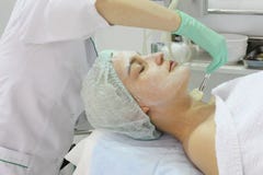 Στο σαλόνι ομορφιάς μια νέα γυναίκα κάνει μια αποφλοίωση στο πρόσωπό της στοκ εικόνες Στο σαλόνι ομορφιάς μια νέα γυναίκα κάνει μια αποφλοίωση στο πρόσωπό της στοκ εικόνες