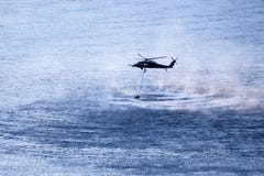 Στρατιωτικό ελικόπτερο που αιωρείται επάνω από τον ποταμό στοκ εικόνες Στρατιωτικό ελικόπτερο που αιωρείται επάνω από τον ποταμό στοκ εικόνες