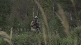 Στρατιώτης με ένα πυροβόλο όπλο στο χέρι του σε έναν λόφο σε ένα δάσος φιλμ μικρού μήκους Στρατιώτης με ένα πυροβόλο όπλο στο χέρι του σε έναν λόφο σε ένα δάσος φιλμ μικρού μήκους