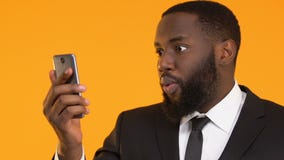 Συγκινημένο μαύρο smartphone εκμετάλλευσης επιχειρησιακών ατόμων, δείκτης χρηματοοικονομικών αγορών προσοχής απόθεμα βίντεο Συγκινημένο μαύρο smartphone εκμετάλλευσης επιχειρησιακών ατόμων, δείκτης χρηματοοικονομικών αγορών προσοχής απόθεμα βίντεο