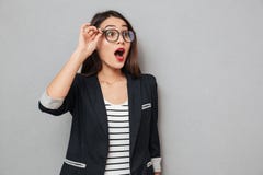Συγκλονισμένη επιχειρησιακή γυναίκα eyeglasses που κοιτάζει μακριά με το ανοικτό στόμα Στοκ Εικόνες Συγκλονισμένη επιχειρησιακή γυναίκα eyeglasses που κοιτάζει μακριά με το ανοικτό στόμα Στοκ Εικόνες