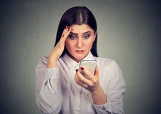 Συγκλονισμένη σοβαρή γυναίκα που εξετάζει το κινητό τηλέφωνό της στοκ φωτογραφίες με δικαίωμα ελεύθερης χρήσης Συγκλονισμένη σοβαρή γυναίκα που εξετάζει το κινητό τηλέφωνό της στοκ φωτογραφίες με δικαίωμα ελεύθερης χρήσης