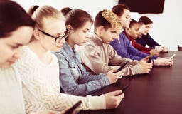 Συμφοιτητές που παίζουν με τα smartphones τους στοκ φωτογραφία Συμφοιτητές που παίζουν με τα smartphones τους στοκ φωτογραφία