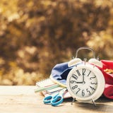 Συναγερμός με τις προμήθειες στο υπόβαθρο πτώσης πίσω σχολικό θέμα στοκ φωτογραφία Συναγερμός με τις προμήθειες στο υπόβαθρο πτώσης πίσω σχολικό θέμα στοκ φωτογραφία