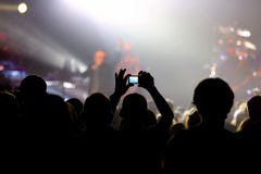 Συναυλία μουσικής με το ακροατήριο και το άτομο που κάνουν τη φωτογραφία στοκ φωτογραφία με δικαίωμα ελεύθερης χρήσης Συναυλία μουσικής με το ακροατήριο και το άτομο που κάνουν τη φωτογραφία στοκ φωτογραφία με δικαίωμα ελεύθερης χρήσης
