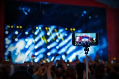 Συναυλία βράχου πυροβολισμού από το smartphone στο ραβδί selfie στοκ εικόνες με δικαίωμα ελεύθερης χρήσης Συναυλία βράχου πυροβολισμού από το smartphone στο ραβδί selfie στοκ εικόνες με δικαίωμα ελεύθερης χρήσης