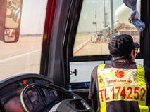 Συνεδρίαση οδηγών λεωφορείου κοντά στο τιμόνι στο λεωφορείο οχημάτων πυκνών δρομολογίων στον αερολιμένα στοκ εικόνες με δικαίωμα ελεύθερης χρήσης Συνεδρίαση οδηγών λεωφορείου κοντά στο τιμόνι στο λεωφορείο οχημάτων πυκνών δρομολογίων στον αερολιμένα στοκ εικόνες με δικαίωμα ελεύθερης χρήσης