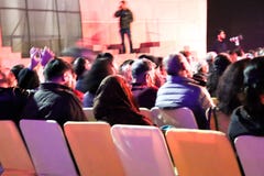 Συνεδρίαση ομάδας ανθρώπων στις καρέκλες και τη σκηνική απόδοση προσοχής ζωντανές στοκ φωτογραφία με δικαίωμα ελεύθερης χρήσης Συνεδρίαση ομάδας ανθρώπων στις καρέκλες και τη σκηνική απόδοση προσοχής ζωντανές στοκ φωτογραφία με δικαίωμα ελεύθερης χρήσης