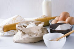 Συστατικά για να ζυμώσει τη ζύμη Αλεύρι στην τσάντα εγγράφου, αυγά, ξηρά ζύμη, γάλα Εργαλεία και τμήματα κουζινών για τη ζύμη στοκ φωτογραφία με δικαίωμα ελεύθερης χρήσης Συστατικά για να ζυμώσει τη ζύμη Αλεύρι στην τσάντα εγγράφου, αυγά, ξηρά ζύμη, γάλα Εργαλεία και τμήματα κουζινών για τη ζύμη στοκ φωτογραφία με δικαίωμα ελεύθερης χρήσης