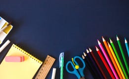 Σχολικές προμήθειες στο σκούρο μπλε υπόβαθρο E στοκ φωτογραφία με δικαίωμα ελεύθερης χρήσης Σχολικές προμήθειες στο σκούρο μπλε υπόβαθρο E στοκ φωτογραφία με δικαίωμα ελεύθερης χρήσης