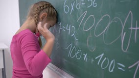 Σχολική εκπαίδευση, θηλυκός μαθητής που στέκεται κοντά στον πίνακα με τα παραδείγματα μαθηματικών απόθεμα βίντεο Σχολική εκπαίδευση, θηλυκός μαθητής που στέκεται κοντά στον πίνακα με τα παραδείγματα μαθηματικών απόθεμα βίντεο