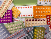 Σωροί των ζωηρόχρωμων χαπιών ελέγχου των γεννήσεων Στοκ Εικόνα Σωροί των ζωηρόχρωμων χαπιών ελέγχου των γεννήσεων Στοκ Εικόνα