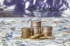 Σωροί των νομισμάτων στις διεσπαρμένες σημειώσεις εκατό δολαρίων σε ένα λαμπρό υπόβαθρο στοκ εικόνες Σωροί των νομισμάτων στις διεσπαρμένες σημειώσεις εκατό δολαρίων σε ένα λαμπρό υπόβαθρο στοκ εικόνες