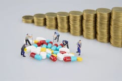 Σωρός της ιατρικής με τους μικροσκοπικούς ανθρώπους και τα νομίσματα θαμπάδων στοκ εικόνα με δικαίωμα ελεύθερης χρήσης Σωρός της ιατρικής με τους μικροσκοπικούς ανθρώπους και τα νομίσματα θαμπάδων στοκ εικόνα με δικαίωμα ελεύθερης χρήσης