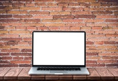 Σύγχρονο lap-top με την κενή άσπρη οθόνη στον ξύλινο πίνακα ενάντια στο θολωμένο παλαιό τουβλότοιχο στοκ φωτογραφίες με δικαίωμα ελεύθερης χρήσης Σύγχρονο lap-top με την κενή άσπρη οθόνη στον ξύλινο πίνακα ενάντια στο θολωμένο παλαιό τουβλότοιχο στοκ φωτογραφίες με δικαίωμα ελεύθερης χρήσης