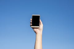 Σύγχρονο smartphone με την κενή οθόνη Ευτυχείς άνθρωποι που παρουσιάζουν σύγχρονα κινητά τηλέφωνα ενάντια στο μπλε ουρανό στοκ εικόνα με δικαίωμα ελεύθερης χρήσης Σύγχρονο smartphone με την κενή οθόνη Ευτυχείς άνθρωποι που παρουσιάζουν σύγχρονα κινητά τηλέφωνα ενάντια στο μπλε ουρανό στοκ εικόνα με δικαίωμα ελεύθερης χρήσης