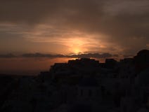 Σύνολα ήλιων πέρα από τον ωκεανό με τη εικονική παράσταση πόλης στοκ εικόνες Σύνολα ήλιων πέρα από τον ωκεανό με τη εικονική παράσταση πόλης στοκ εικόνες