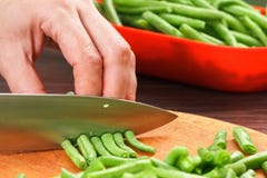 Τέμνοντα φασόλια αρχιμαγείρων για το μαγείρεμα Απόθεμα επάνω στα χειμερινά τρόφιμα στοκ εικόνα Τέμνοντα φασόλια αρχιμαγείρων για το μαγείρεμα Απόθεμα επάνω στα χειμερινά τρόφιμα στοκ εικόνα
