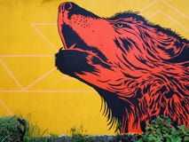 Τέχνη οδών: Κόκκινα howls λύκων μπροστά από τον κίτρινο τοίχο στοκ εικόνες με δικαίωμα ελεύθερης χρήσης Τέχνη οδών: Κόκκινα howls λύκων μπροστά από τον κίτρινο τοίχο στοκ εικόνες με δικαίωμα ελεύθερης χρήσης