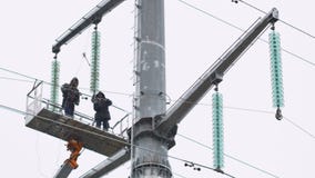 Τα διαγραμμιστές λειτουργούν με τα καλώδια στη γραμμή μετάδοσης από τη γιρλάντα μονωτών απόθεμα βίντεο Τα διαγραμμιστές λειτουργούν με τα καλώδια στη γραμμή μετάδοσης από τη γιρλάντα μονωτών απόθεμα βίντεο