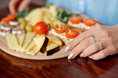 Τα θηλυκά χέρια κινηματογραφήσεων σε πρώτο πλάνο κρατούν τον τέμνοντα πίνακα με το prosciutto, το σαλάμι, το τυρί, τα ραβδιά ψωμι στοκ φωτογραφία με δικαίωμα ελεύθερης χρήσης Τα θηλυκά χέρια κινηματογραφήσεων σε πρώτο πλάνο κρατούν τον τέμνοντα πίνακα με το prosciutto, το σαλάμι, το τυρί, τα ραβδιά ψωμι στοκ φωτογραφία με δικαίωμα ελεύθερης χρήσης