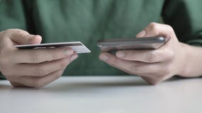 Τα θηλυκά χέρια κρατούν ένα μεγάλες μαύρες smartphone και πιστωτική μια κάρτα, σε απευθείας σύνδεση τραπεζικές εργασίες, ψωνίζοντ Τα θηλυκά χέρια κρατούν ένα μεγάλες μαύρες smartphone και πιστωτική μια κάρτα, σε απευθείας σύνδεση τραπεζικές εργασίες, ψωνίζοντ